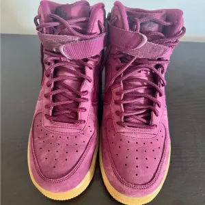 Burgundy high top Air Force ones.